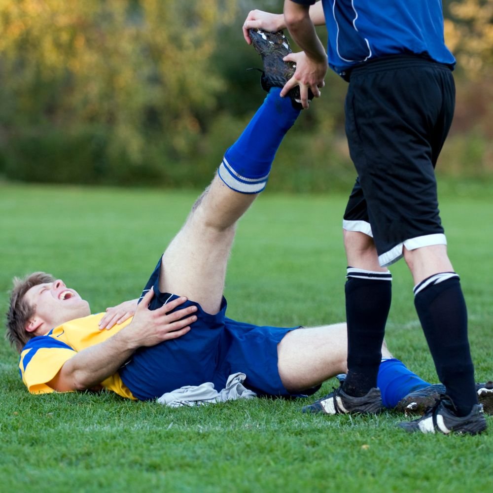 Athlete experiencing a leg cramp on the field